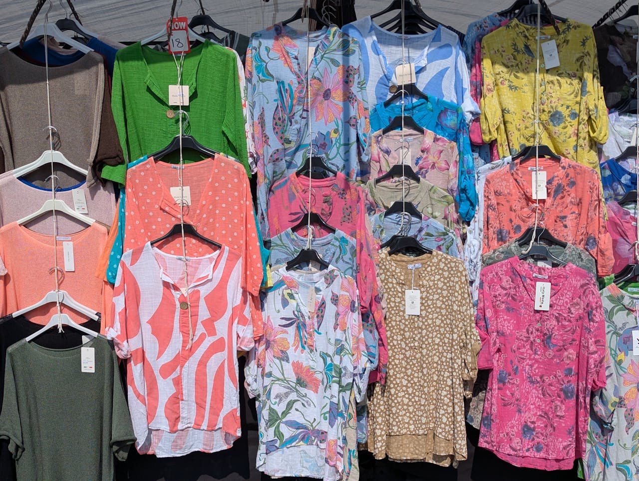 A vibrant display of summer blouses in various patterns, showcased at a market in Knaresborough, England.