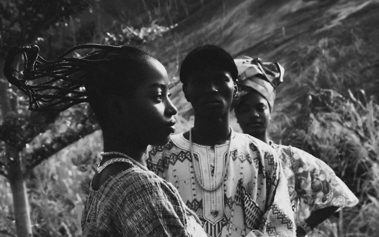 Home Artistic black and white portrait of people in traditional African clothing outdoors.